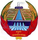 Crest of the communist republic of Democratic Kampuchea (1975-1979). The symbolism celebrates theoretical agricultural and industrial advances with emphasis on irrigation works, rice fields and a factory.
