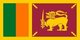The Flag of Sri Lanka, also called the Lion Flag, consists of a gold lion, holding a sword in its right fore paw, in front of a crimson background.<br/><br/>

Sri Lanka had always been an important port and trading post in the ancient world, and was increasingly frequented by merchant ships from the Middle East, Persia, Burma, Thailand, Malaysia, Indonesia and other parts of Southeast Asia. The islands were known to the first European explorers of South Asia and settled by many groups of Arab and Malay merchants.<br/><br/>

A Portuguese colonial mission arrived on the island in 1505 headed by Lourenço de Almeida, the son of Francisco de Almeida. At that point the island consisted of three kingdoms, namely Kandy in the central hills, Kotte at the Western coast, and Yarlpanam (Anglicised Jaffna) in the north. The Dutch arrived in the 17th century. The British East India Company took over the coastal regions controlled by the Dutch in 1796, and in 1802 these provinces were declared a crown colony under direct rule of the British government, therefore the island was not part of the British Raj. The annexation of the Kingdom of Kandy in 1815 by the Kandyan convention, unified the island under British rule.<br/><br/>

European colonists established a series of cinnamon, sugar, coffee, indigo cultivation followed by tea and rubber plantations and graphite mining. The British also brought a large number of indentured workers from Tamil Nadu to work in the plantation economy. The city of Colombo was developed as the administrative centre and commercial heart with its harbor, and the British established modern schools, colleges, roads and churches that introduced Western-style education and culture to the Ceylonese.<br/><br/>

On 4 February 1948 the country gained its independence as the Dominion of Ceylon. It changed its name to Sri Lanka in 1972.